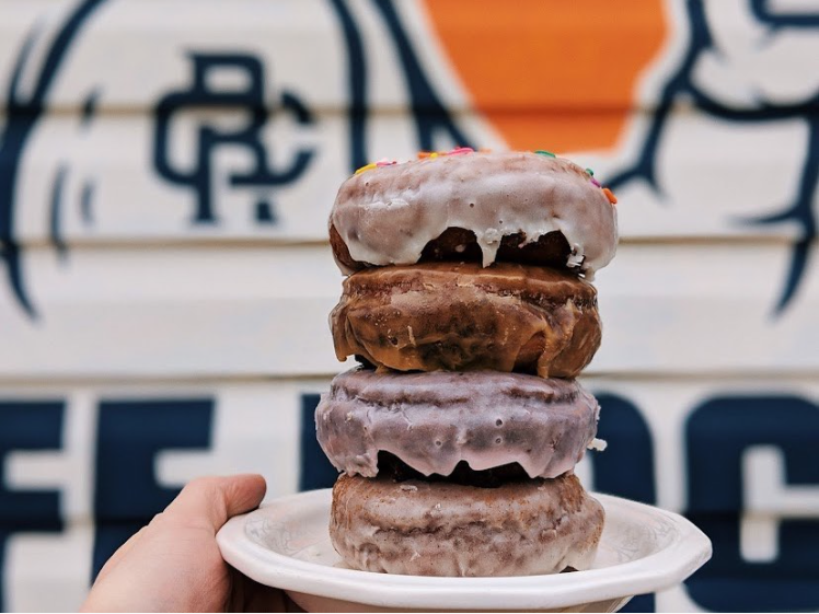Someone holding a plate of Cafe Racer specialty donuts